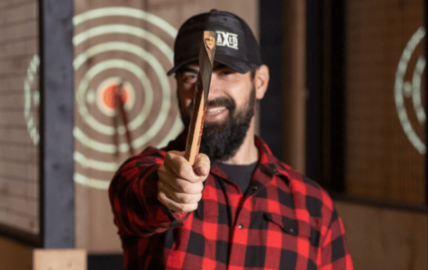 Man in buffalo plaid shirt throwing an axe